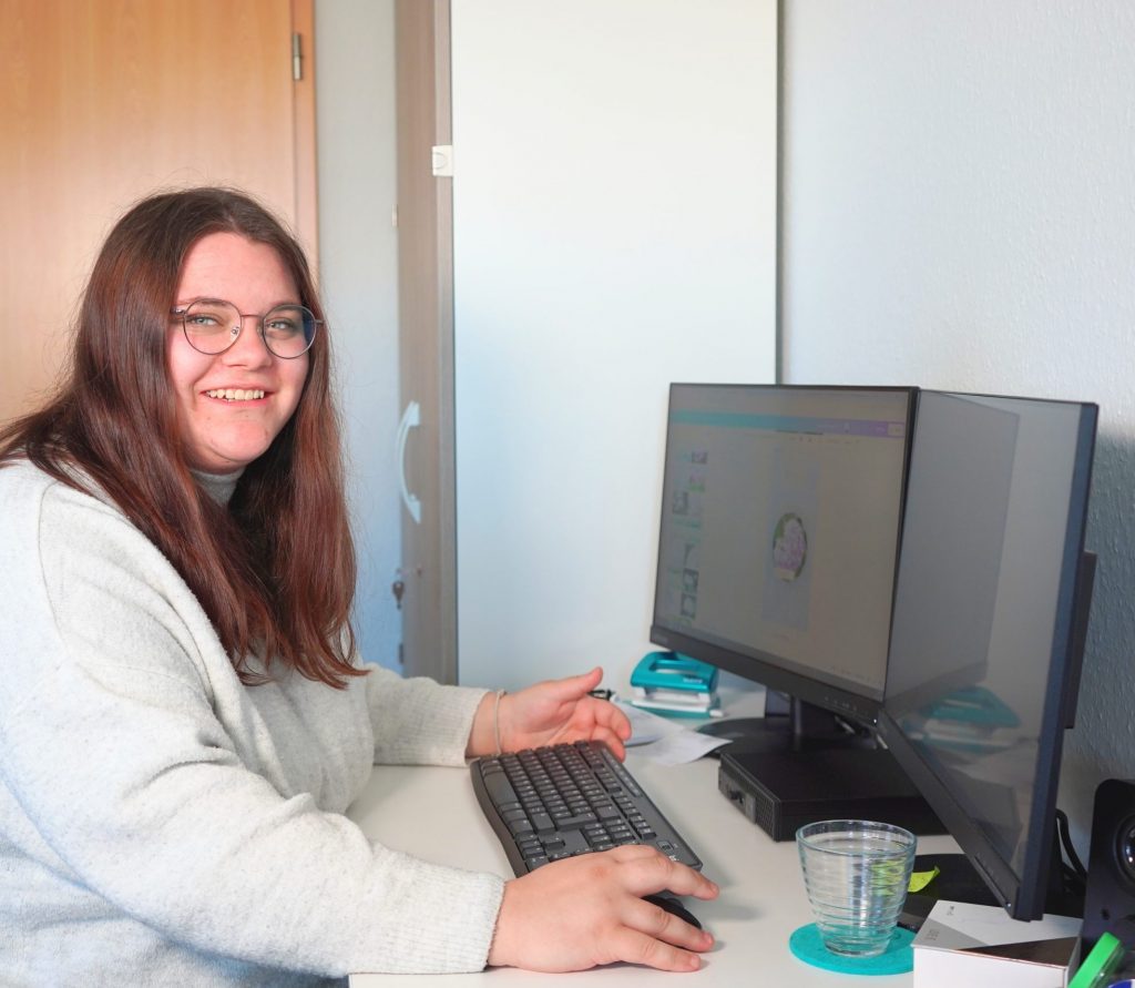 Eine Frau arbeitet im Büro an zwei Monitoren – Symbolbild für kreative Projekte und digitale Strategien in einer Werbeagentur und Marketingagentur.