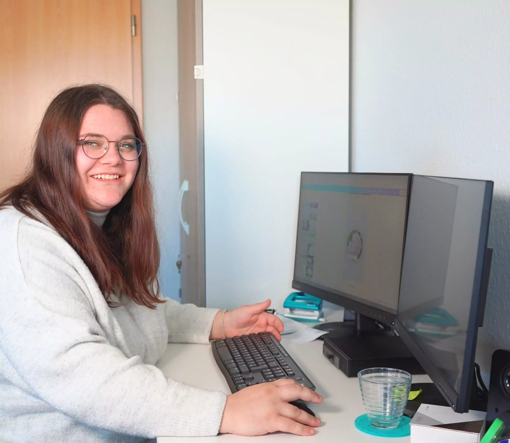 Eine Frau arbeitet im Büro an zwei Monitoren – Symbolbild für kreative Projekte und digitale Strategien in einer Werbeagentur und Marketingagentur.