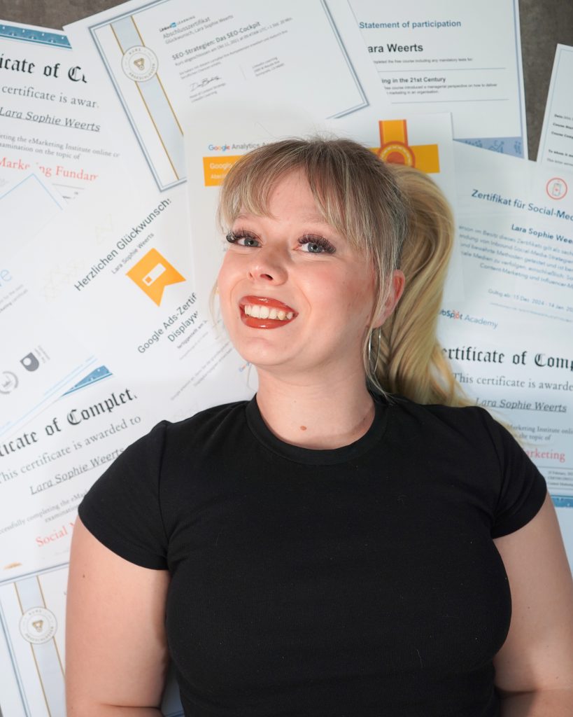 Social-Media-Expertin vor ihren Marketing- und SEO-Zertifikaten. Zur Präsentation von Fachwissen, Online-Marketing-Kompetenz und professioneller Weiterbildung.